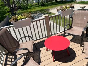 a red table and two chairs on a balcony at Sexy Suite in Cedarburg