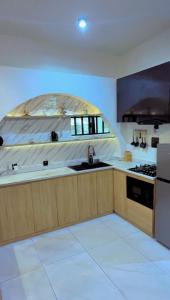 a kitchen with a sink and a stove at De Rich Residence Apartment in Benin City