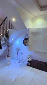 a white room with a staircase and a potted plant at De Rich Residence Apartment in Benin City