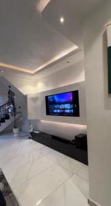 a living room with a flat screen tv on a wall at De Rich Residence Apartment in Benin City