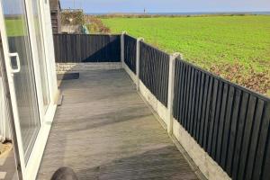 a wooden porch with a fence and a field at Beach 100m - Sea View - Log Burner - Dogs Welcome in Bridlington