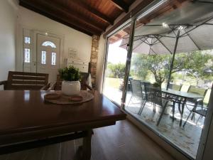 a dining room with a table and an umbrella at KONSTANTINOS Luxury Living in Ofrínion