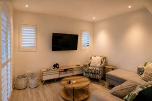 a living room with a couch and a tv at Yzer4You in Yzerfontein