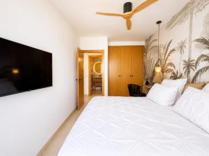 a bedroom with a white bed and a flat screen tv at Ocean View in Puerto de Santiago +23 photos