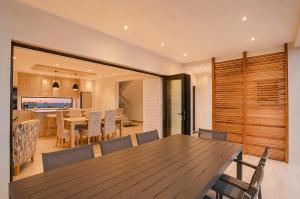 a dining room and kitchen with a wooden table and chairs at Yzer4You in Yzerfontein