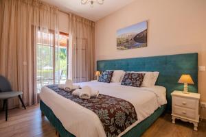 a bedroom with a large bed with a blue headboard at Summer Nights Resort in Ipsos
