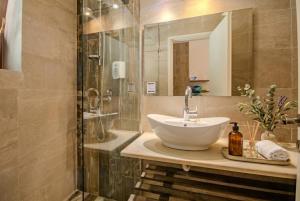 a bathroom with a sink and a shower at Summer Nights Resort in Ipsos +30 photos