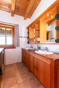 a kitchen with a sink and wooden cabinets at Loderbichl Alm Ferienwohnungen in Lofer +153 photos