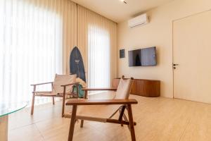 a room with three chairs and a surfboard on the wall at Surfside Uluwatu Resort in Uluwatu +29 photos