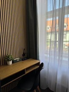 a desk with a chair next to a window at Zelena Ratolest in České Budějovice