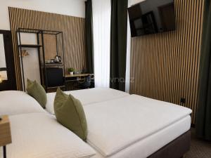 two beds in a hotel room with a mirror at Zelena Ratolest in České Budějovice
