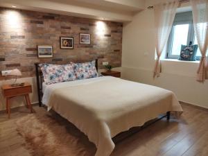 a bedroom with a bed and a brick wall at ''Shinohori'' Olive-Tree Apartment in Argos