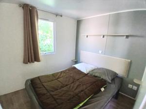 a bed in a room with a window at Camping de Bourges in Bourges