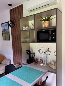 ein Wohnzimmer mit einem Tisch und einer Mikrowelle in der Unterkunft Peak View Tiny House - Piatra Craiului Nest in Zărneşti + 56 Fotos