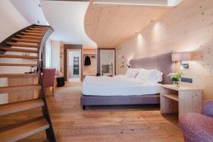 a bedroom with a large bed and a staircase at Hotel Li Anta Rossa - Adults Only in Livigno +107 photos