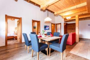 a dining room with a wooden table and blue chairs at Loderbichl Alm Ferienwohnungen in Lofer