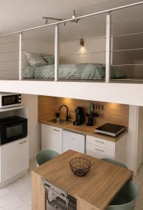 a kitchen with white cabinets and a wooden table at studio les volets bleus in Boulogne-sur-Mer