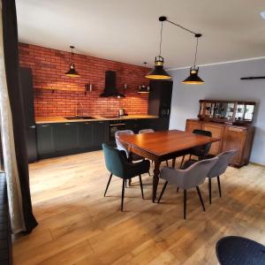 a kitchen and dining room with a wooden table and chairs at LoftLove Lubianka in Starachowice