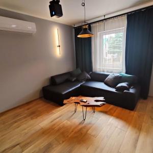 a living room with a black couch and a coffee table at LoftLove Lubianka in Starachowice
