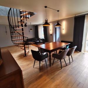 a dining room with a table and chairs and a spiral staircase at LoftLove Lubianka in Starachowice