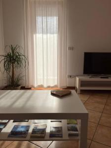 a living room with a table and a tv at Al Monte Zelo in Agordo