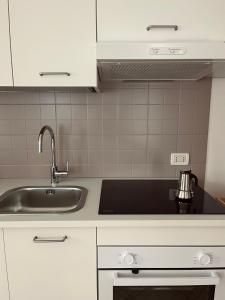 a kitchen with white cabinets and a sink at Al Monte Zelo in Agordo