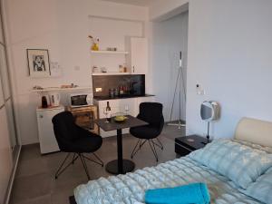 ein Wohnzimmer mit Tisch, Stühlen und Sofa in der Unterkunft Cozy studio! in Paphos City
