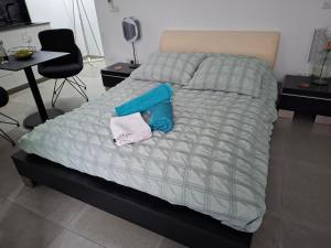 ein Bett mit einer blauen Decke und einem Handtuch darauf in der Unterkunft Cozy studio! in Paphos City