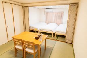 a dining room with a table and a mirror at IJIRIGoodStay in Fukuoka