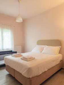a bedroom with a bed with two towels on it at Morpheas Apartment in Central Myrina in Myrina