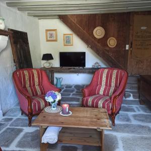 two chairs and a coffee table in a living room at La Maison des 2L in Saint-Médard