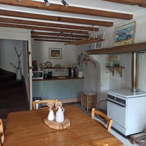 a kitchen with a wooden table with vases on it at La Maison des 2L in Saint-Médard