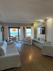 a hotel room with two beds and a living room at Elegance Comfort Natal Beira mar Coberturas Vip in Natal