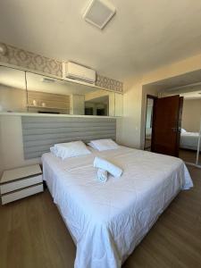 a bedroom with a large white bed with towels on it at Elegance Comfort Natal Beira mar Coberturas Vip in Natal +23 photos