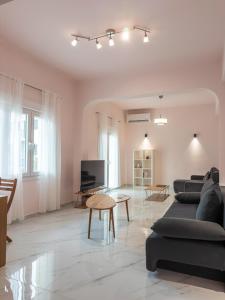 a living room with two couches and a tv at Morpheas Apartment in Central Myrina in Myrina