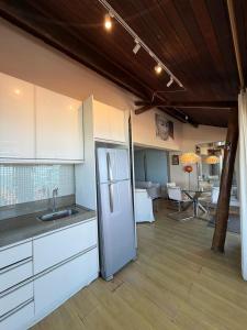 a kitchen with a refrigerator and a dining room at Elegance Comfort Natal Beira mar Coberturas Vip in Natal