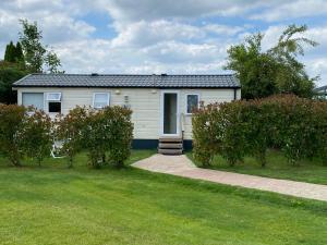 a small white house with a grass yard at B&B De Turfsteker in Emmer-Compascuum