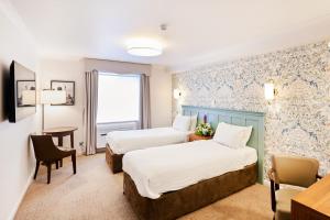 a hotel room with two beds and a desk at Milford Hall Salisbury in Salisbury