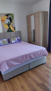 a bedroom with a bed with a pink bedspread at Vesna apartmani, Igalo in Igalo