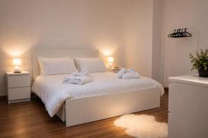 a bedroom with a white bed with two stuffed animals on it at Casa DiMont Sauna & Relax in Salino +21 photos