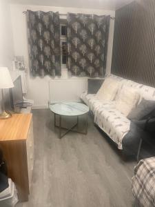 a living room with a couch and a table at Room Younis in Tilehurst