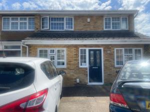 two cars parked in front of a brick house at Room Younis in Tilehurst