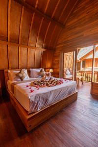 a bedroom with a bed with flowers on it at Two Sisters Villa with Pool - Sire in Tanjung