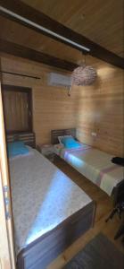 a room with two beds in a wooden cabin at Sunshine House Ada Bojana in Ulcinj
