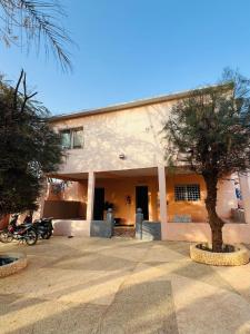 ein Gebäude mit einem Baum davor in der Unterkunft Chalet rose in Toubab Dialao
