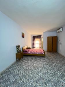 ein leeres Zimmer mit einem Bett und einem Fenster in der Unterkunft Chalet rose in Toubab Dialao