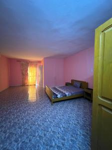ein Schlafzimmer mit einem Bett in einem rosa Zimmer in der Unterkunft Chalet rose in Toubab Dialao
