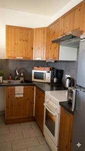 a kitchen with wooden cabinets and a white stove top oven at L'OUSTAL D'ADELE proche Canal du Midi et Moissac in Saint-Nicolas-de-la-Grave +11 photos