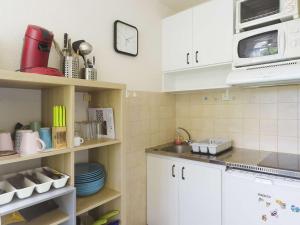 a kitchen with white cabinets and a microwave at Appartement avec mezzanine pour 4, vue sur Gourette - FR-1-400-49 in Gourette +6 photos