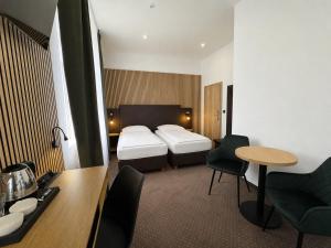 a hotel room with two beds and a table at Zelena Ratolest in České Budějovice